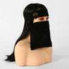 Model wearing a black face veil with a gold crown headband.