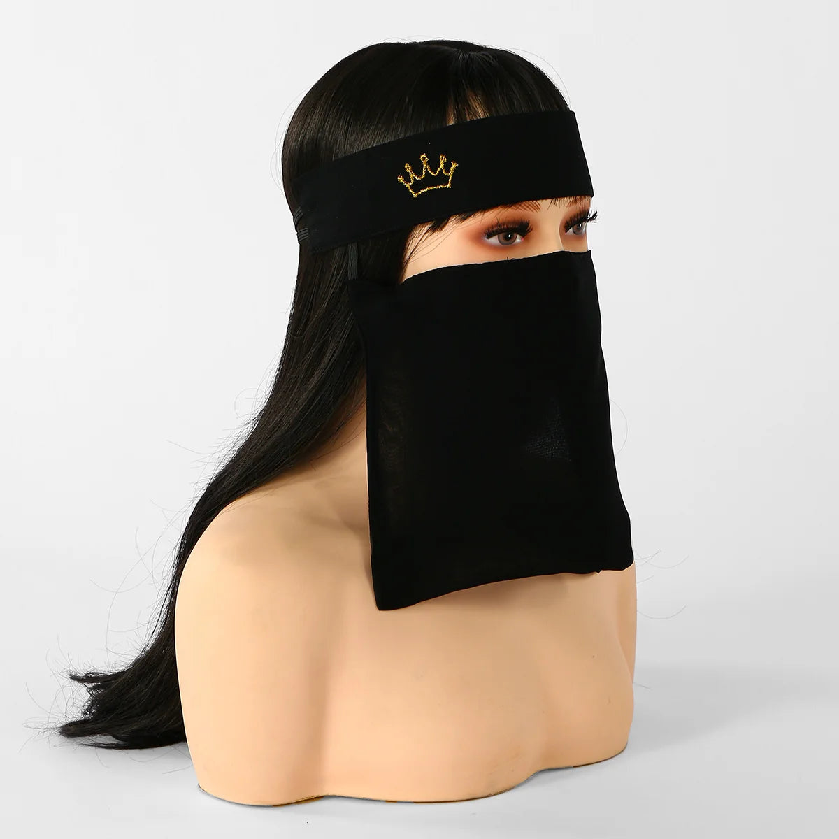 Model wearing a black face veil with a gold crown headband.