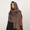 Una mujer modela un pañuelo pashmina de lujo con patrón marrón oscuro y dorado sobre su cabeza.