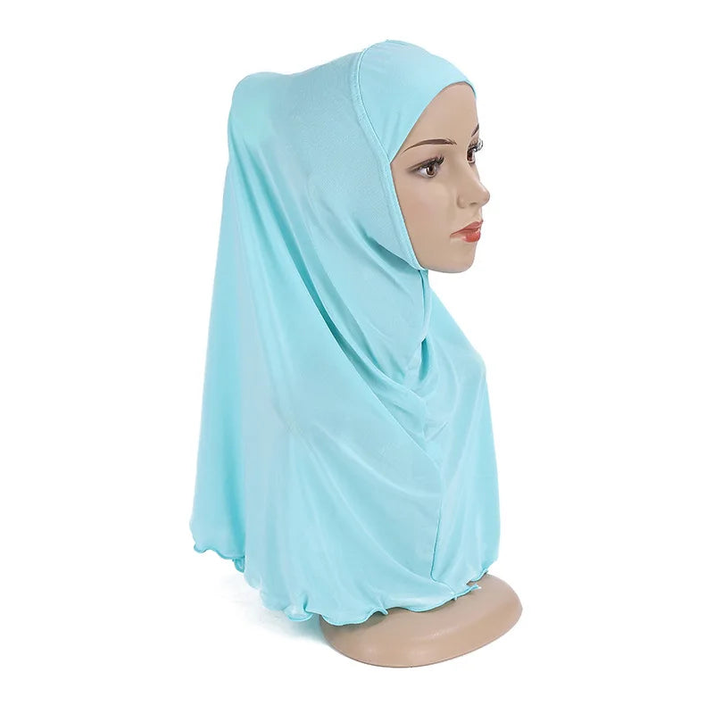 Un chal de hijab azul claro para niños drapeado sobre la cabeza y los hombros de un maniquí.