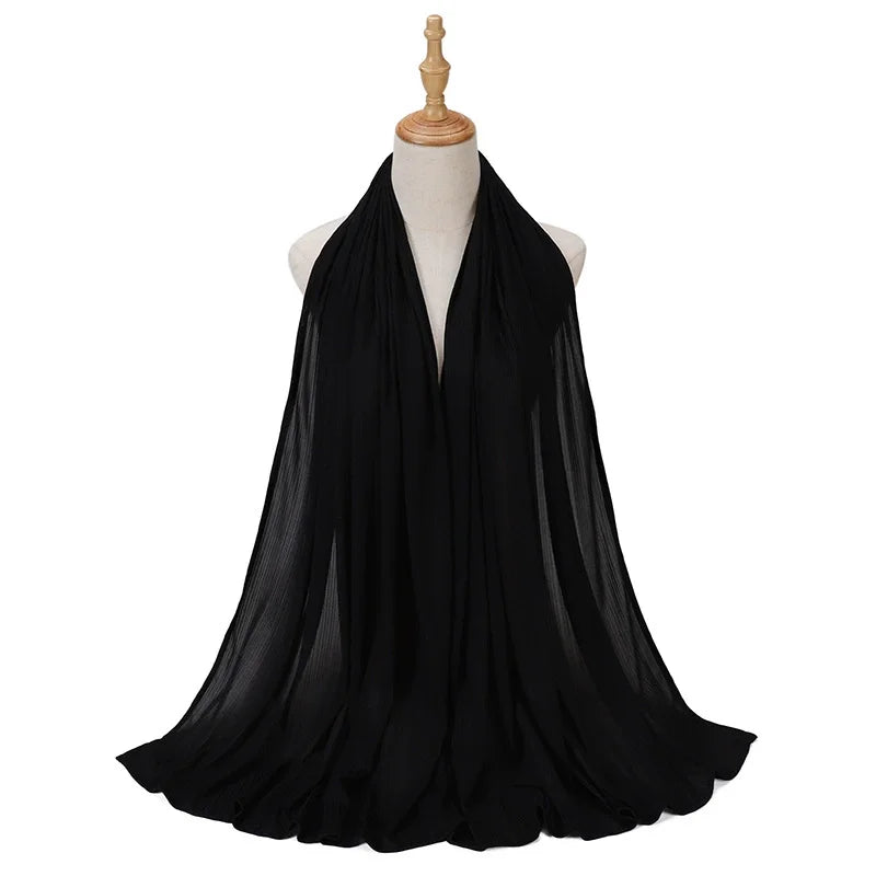 Bufanda de jersey de algodón negro, drapeada en el cuello de un maniquí