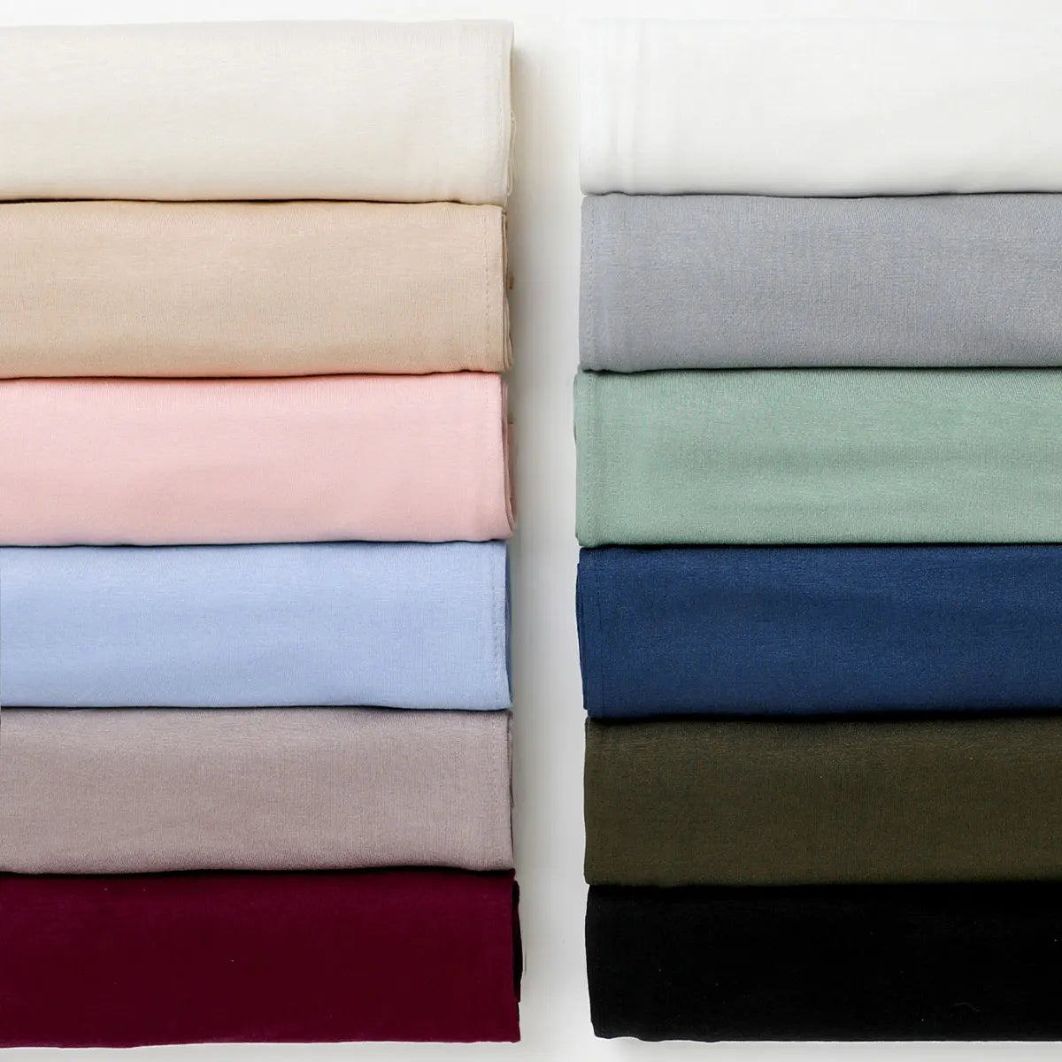 Eine Ansammlung von einfarbigen Chiffon-Schals oder Überwürfen in einer Reihe.