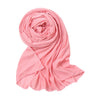 Rosa, einfacher Baumwoll-Jersey-Schal, gerollt und über einer weißen Fläche drapiert.