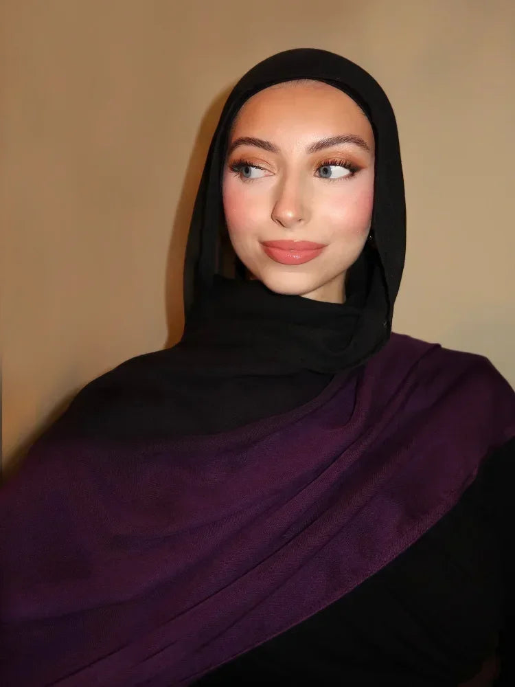Eine Frau trägt einen lila Farbverlauf-rayon-modalen Hijab und schwarze Kleidung.