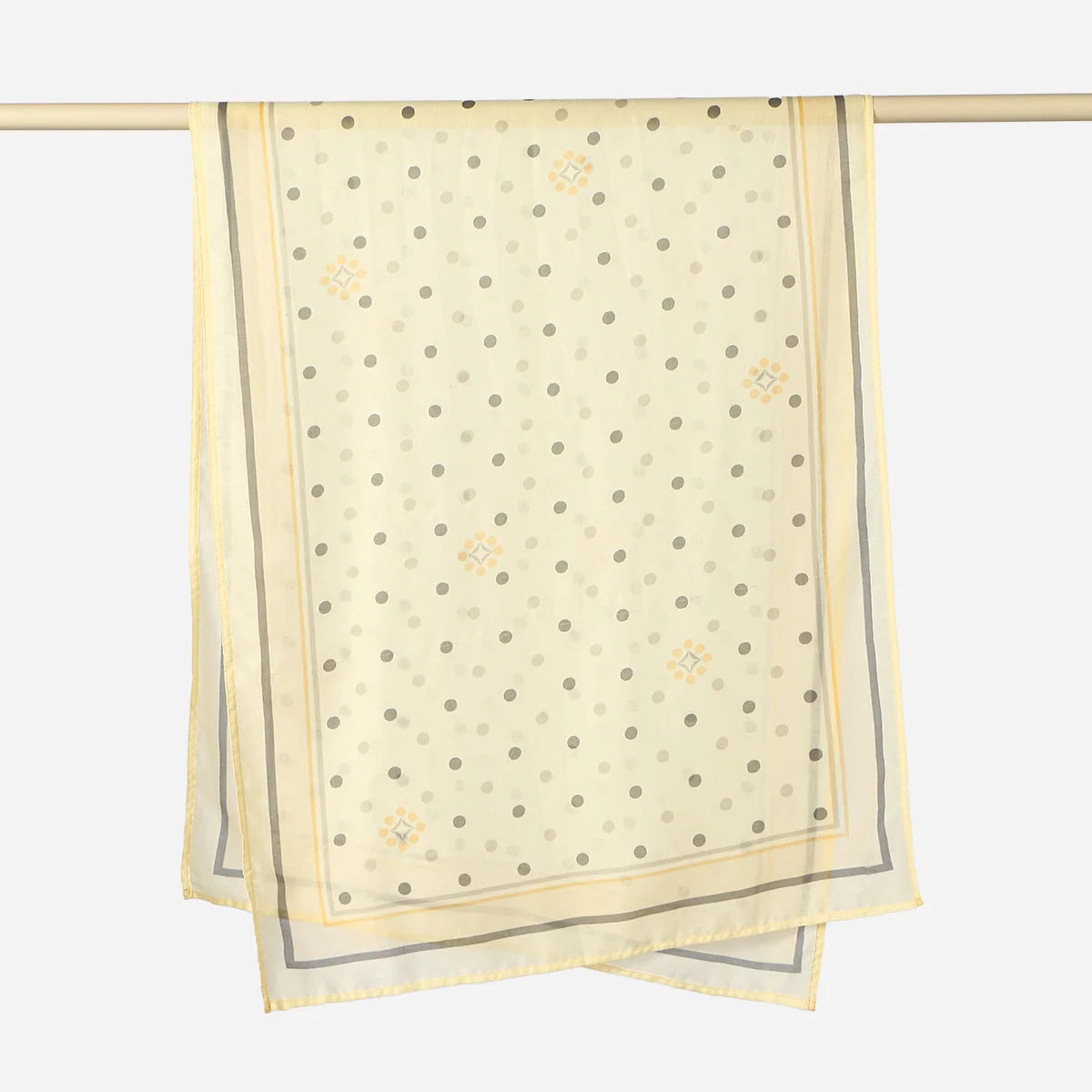 A light beige linen hijab scarf with a subtle pattern of small dots and floral motifs hanging on a wooden rod.