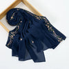 A dark navy blue chiffon hijab shawl with delicate floral embroidery, displayed on a wooden frame.