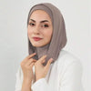 Une femme portant un bonnet instant hijab double couche taupe uni et des vêtements blancs.