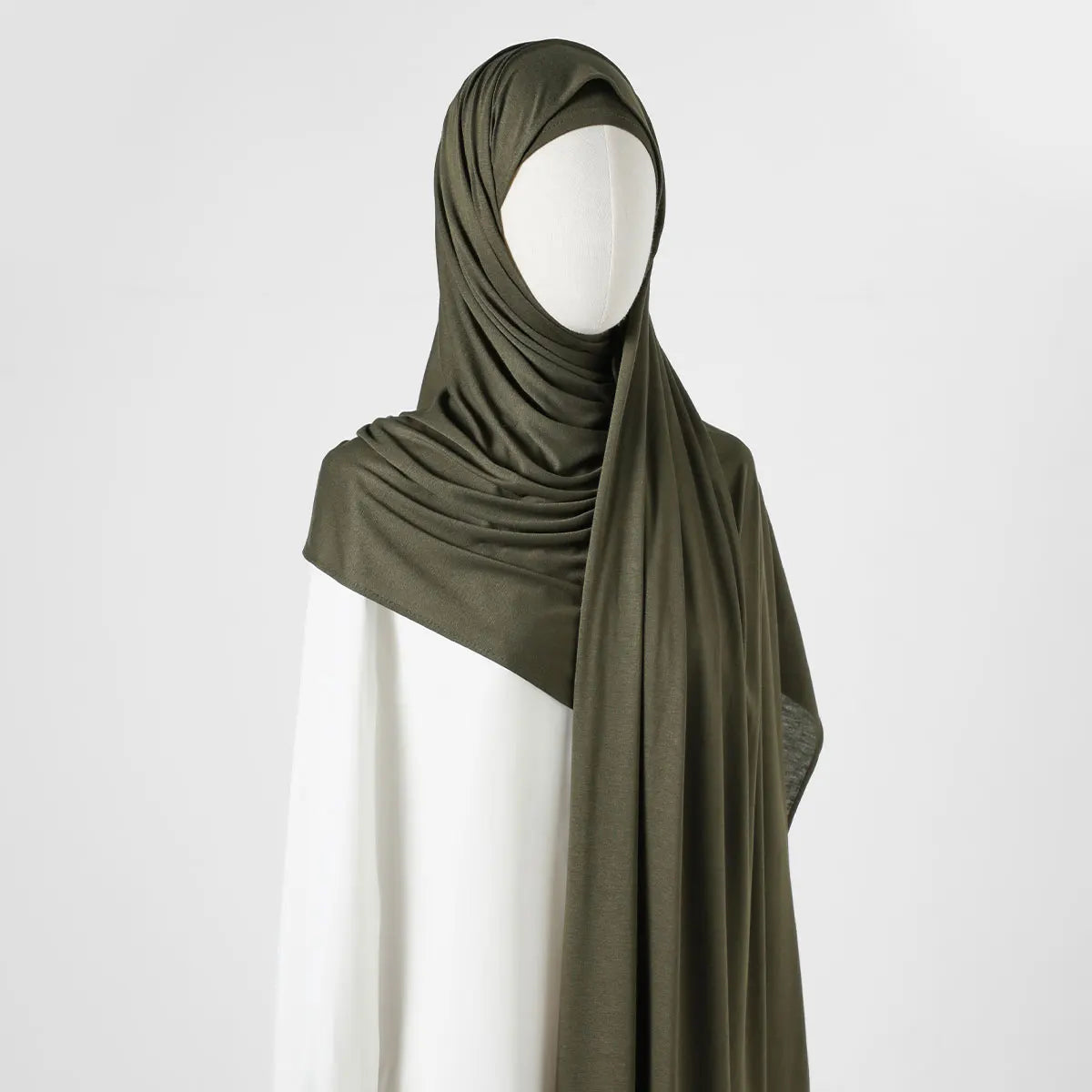 Ein Modell trägt einen eleganten, einfarbigen Chiffon-Schal in olivgrün.