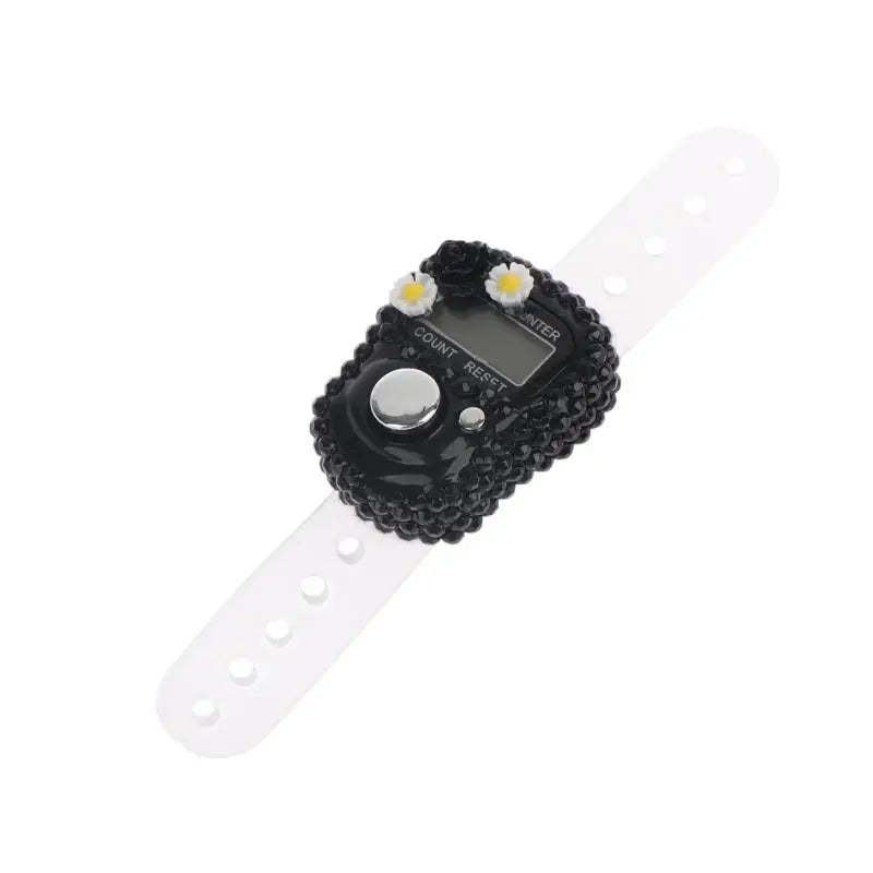A black finger counter device with a white strap and a display showing count and reset options.