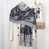 Schwarz-weißes Paisley-Viskose-Hijab-Tuch um einen beige Blazer mit goldenen Schmuck drapiert.