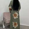 A full-length view of a moss green abaya kaftan dress with large floral print details.