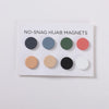 Tarjeta blanca con seis pines magnéticos redondos de hijab en varios colores como negro, azul-gris, verde oliva, coral y beig