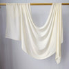 Foulard modal de couleur crème drapé sur un cintre doré sur fond blanc.