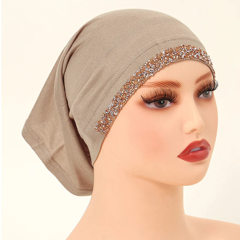 Modelo usando un hiyab interior elástico de algodón modal beige con ribete dorado brillante.