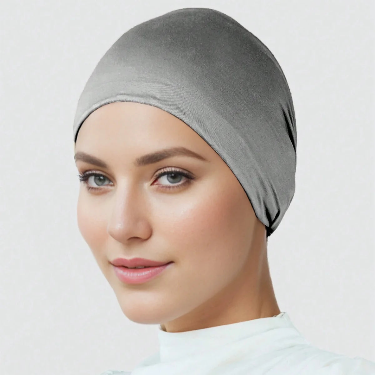 Eine Frau trägt eine graue Premium-Stretch-Baumwoll-Hijab-Unterkappe.