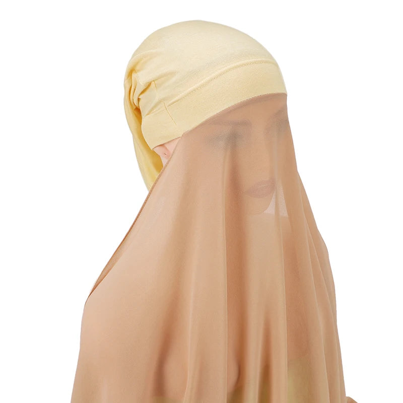 Una mujer vistiendo un conjunto de hijab y chal de chifón instantáneo amarillo claro.