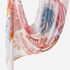 A flowing linen hijab scarf featuring a watercolor print with pink, orange, and blue botanical patterns.