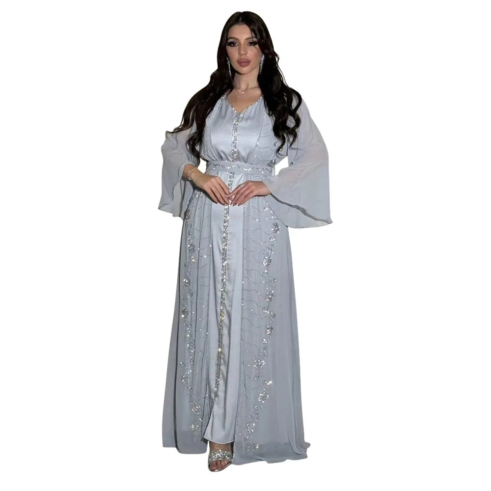Eine Frau modelliert ein elegantes, zweiteiliges muslimisches Set in hellgrau mit silbernen Verzierungen.