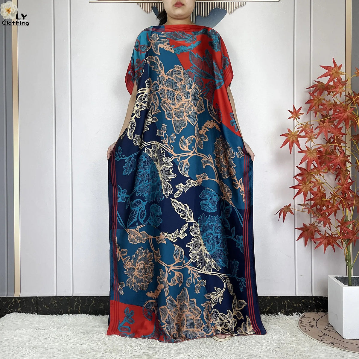 Eine Frau trägt ein blau-orangefarbenes Blumenmuster-Sommerseiden-Abaya-Kaftankleid.