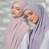 Une femme portant un foulard turban en tissu coton chanvre rose pâle.