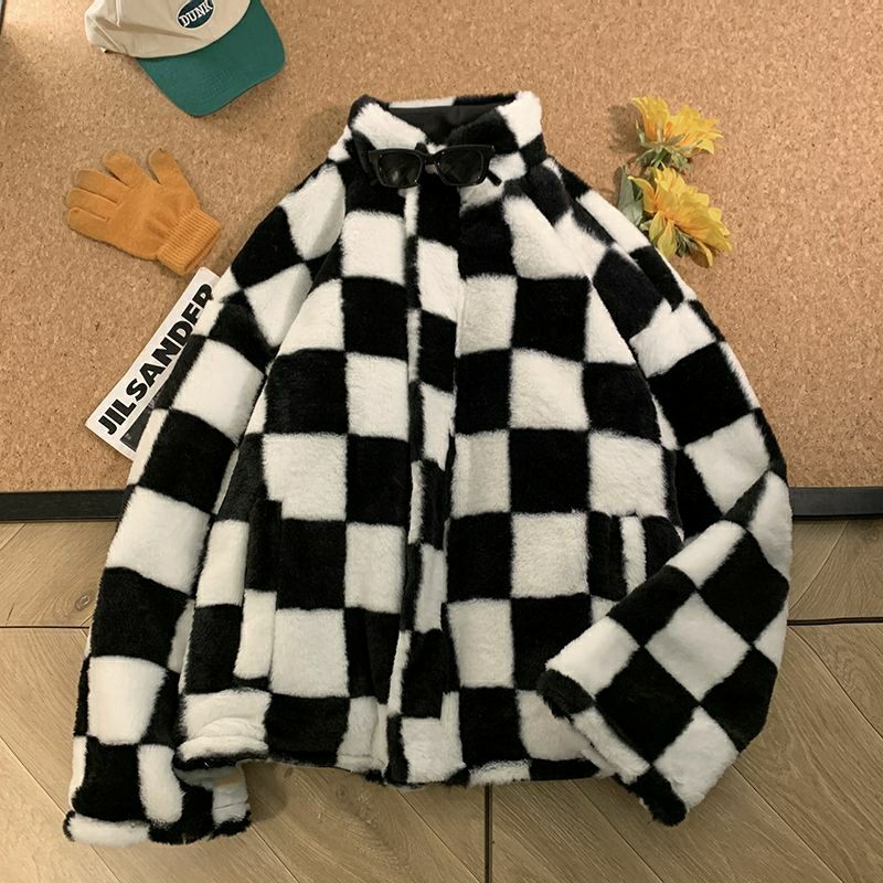 Chaqueta parka de invierno para mujer de piel sintética a cuadros blanco y negro, exhibida sobre una superficie de madera.