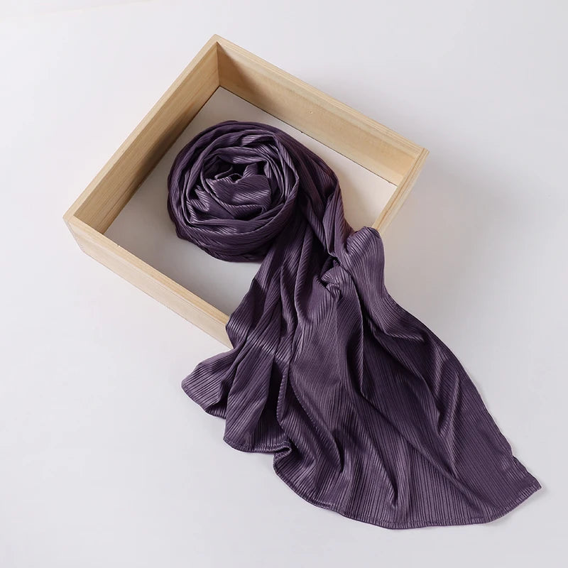 A purple ribbed jersey hijab scarf draped within a light wooden frame.