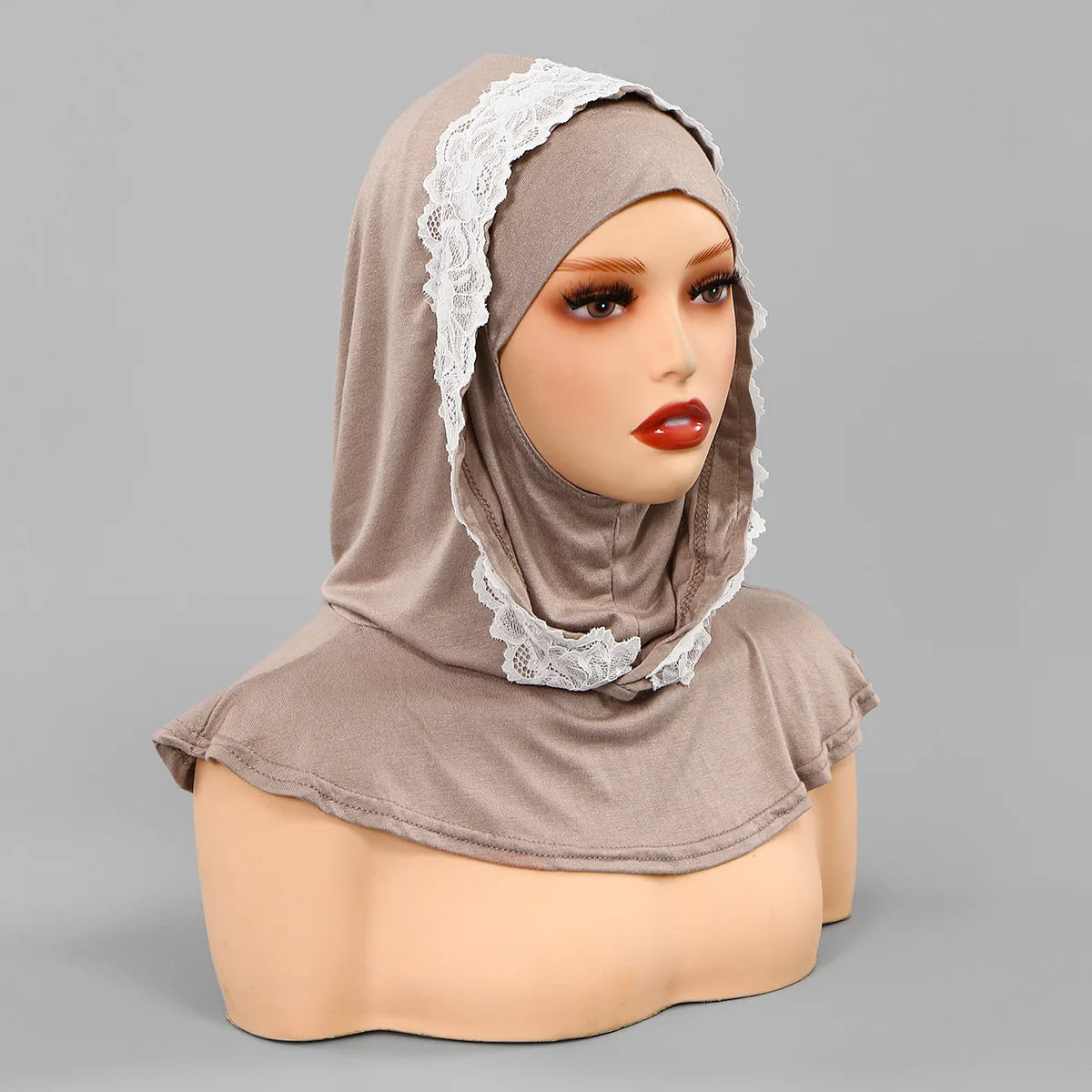 Un mannequin portant un bonnet hijab double couche beige avec bordure en dentelle blanche.