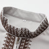 Close-up of a white Moroccan men's ethnic thobe with a stand collar and brown embroidered detailing.