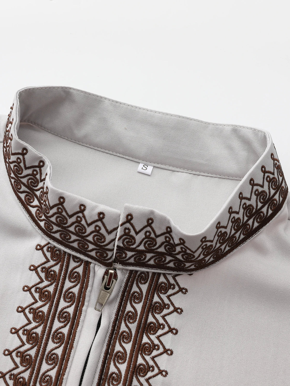 Close-up of a white Moroccan men's ethnic thobe with a stand collar and brown embroidered detailing.