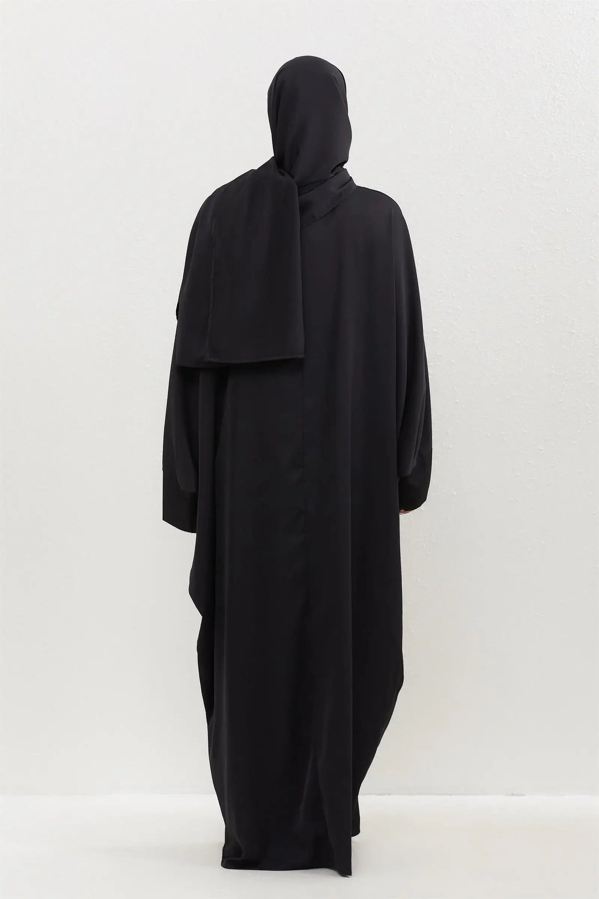 Lange schwarze traditionelle, schlichte Abaya, die von hinten gezeigt wird.