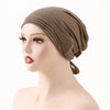 A model wearing a taupe adjustable elastic headband hijab cap