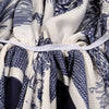 A close-up of an elegant satin silk instant hijab scarf featuring a blue and white patterned fabric gathered with a white tie