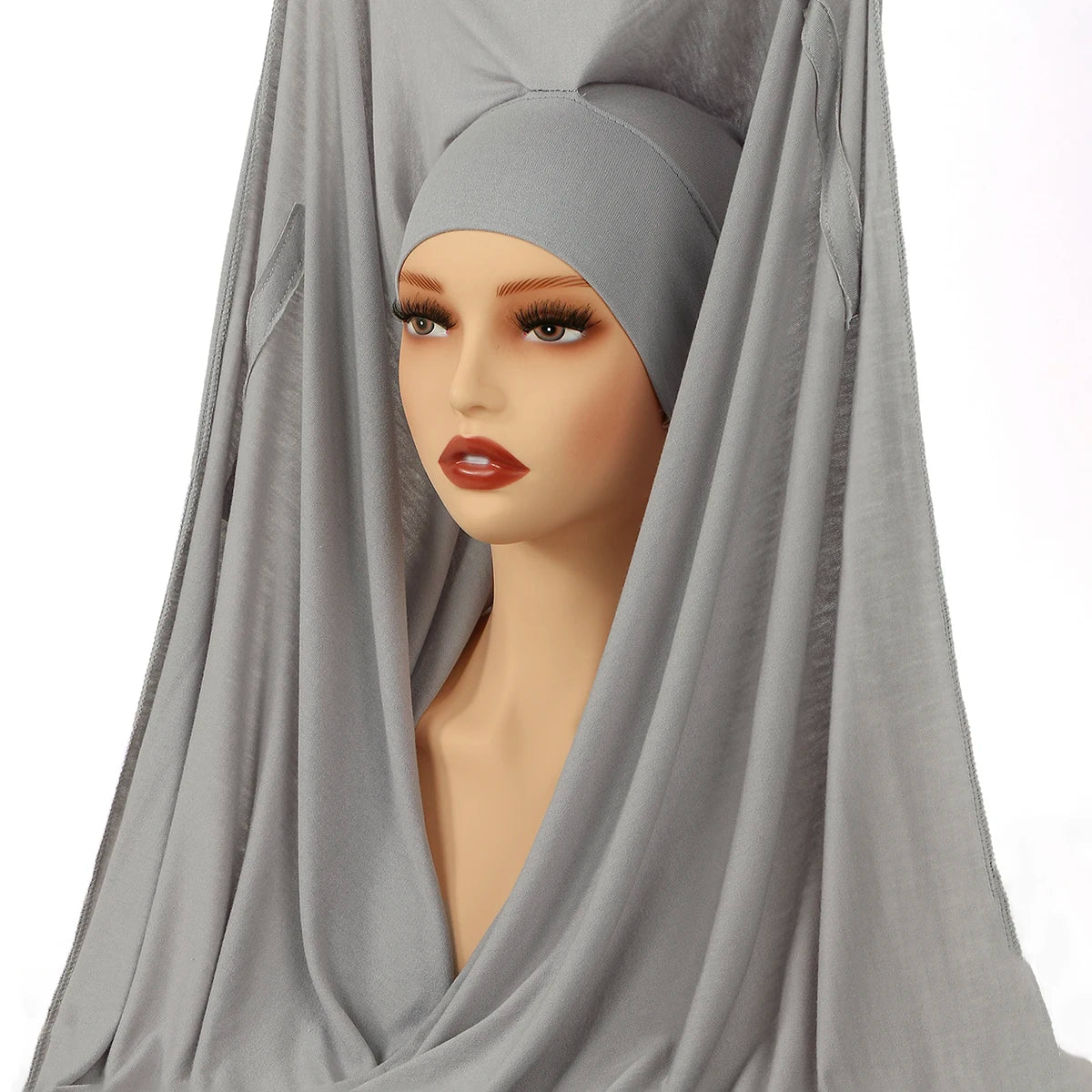 Ein Model trägt einen eleganten grauen Modal-Jersey-Hijab, der über Kopf und Schultern drapiert ist.