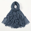 Pañuelo de hijab elegante de bambú azul oscuro drapeado alrededor del cuello.