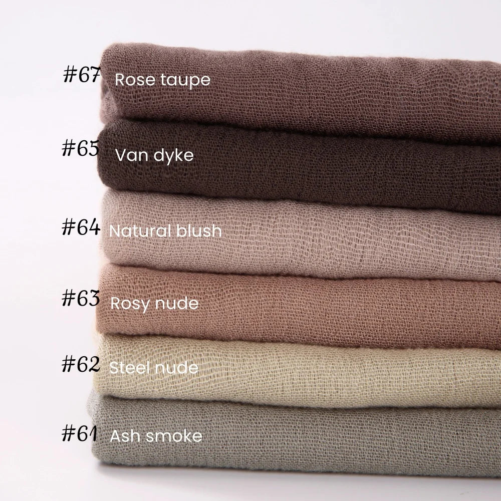 Pile de foulards hijab en coton viscose beige et taupe avec pompons, numéros 61 à 67.