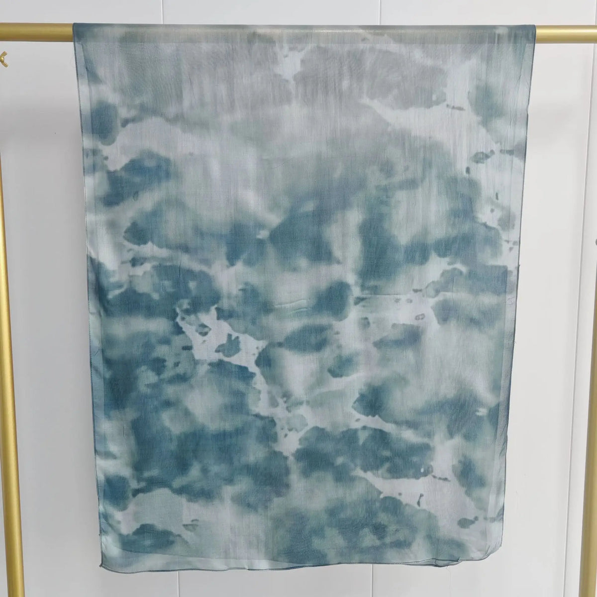 Hellblaue und graue Aquarellschal-Druck, präsentiert vor weißem Hintergrund.