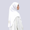 Une femme portant un hijab blanc avec broderie dorée, vue de profil.