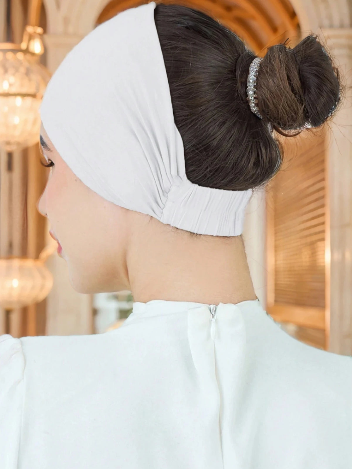 Nahaufnahme eines Profils einer Frau mit weißem Stretch-Baumwoll-Hijab-Underscarf und einem weißen Oberteil.