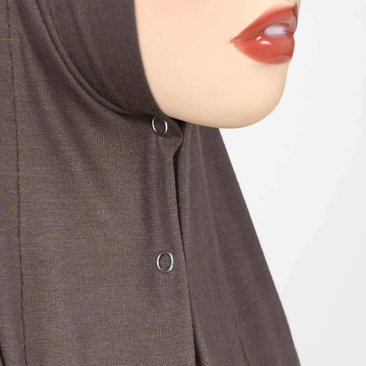 Primer plano del rostro de una mujer vistiendo un hijab de jersey de algodón instantáneo marrón oscuro.