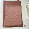 A folded dusty rose soft modal rayon hijab set for women displayed on a white surface.
