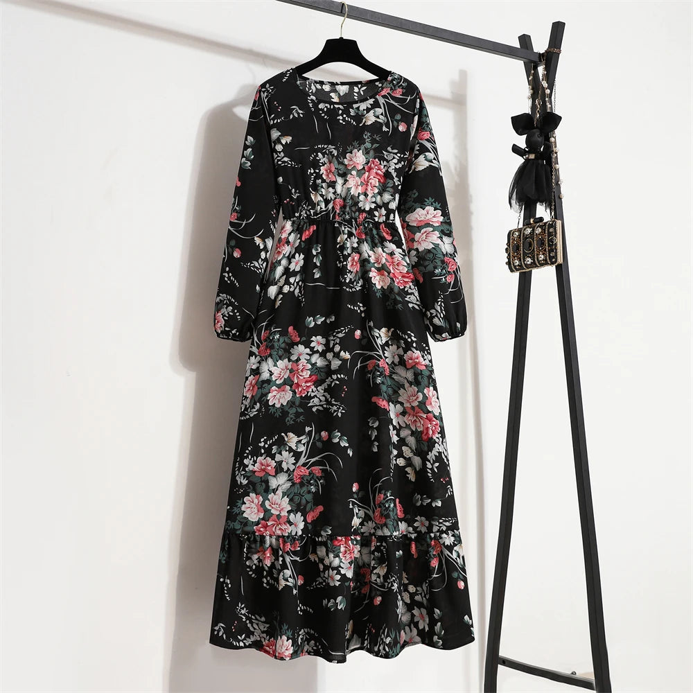 Schwarzes Maxi-Kleid mit Blumenmuster hängt an einem schwarzen Kleiderständer.