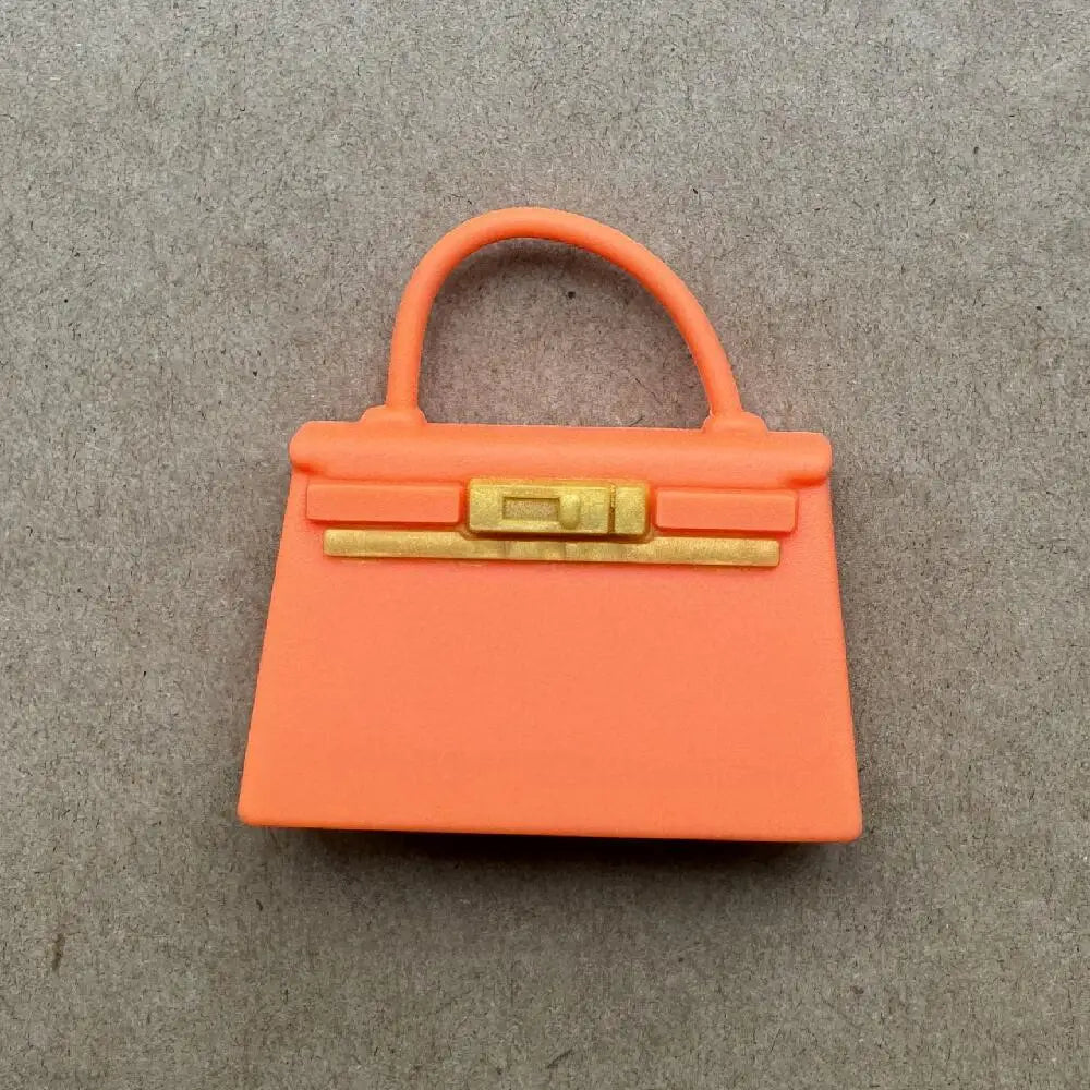 Accesorio de bolso de apariencia de cuero naranja con cierre y asa dorados.