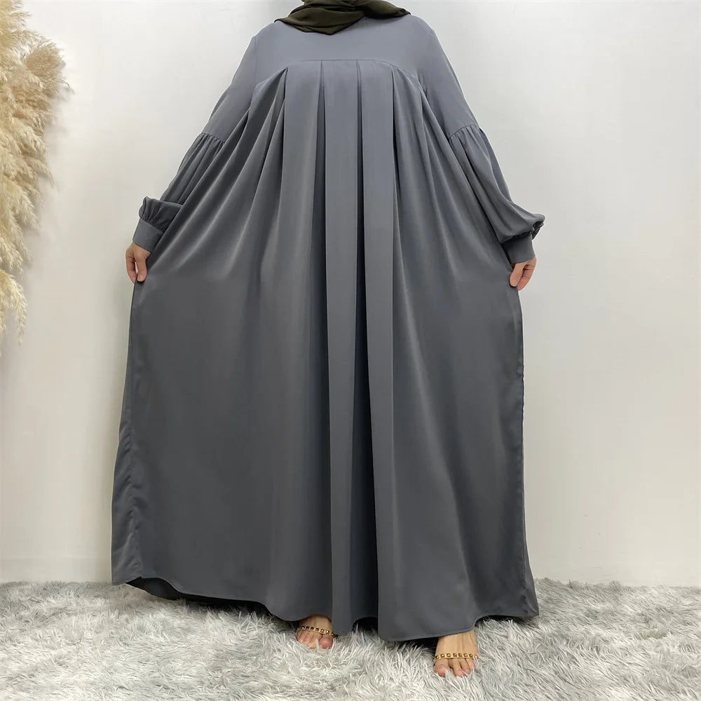 Langes, fließendes graues islamisches Kleid für Damen mit langen Ärmeln und drapiertem Stoff.