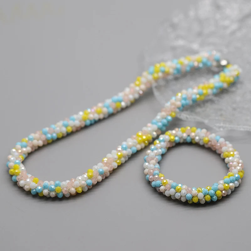 Zarte Perlenkette mit kleinen weißen, pinken und blauen Perlen auf einem dünnen Faden.