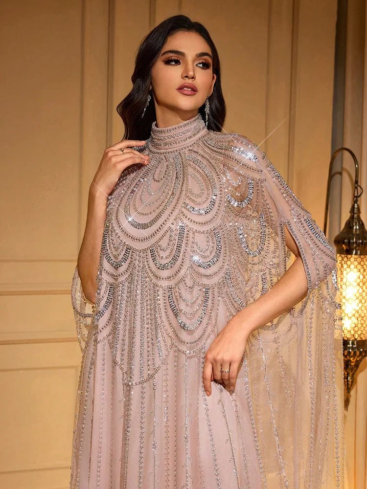 Una mujer vistiendo una elegante bata batwing transparente tono rosa con bordado de plata delicado.