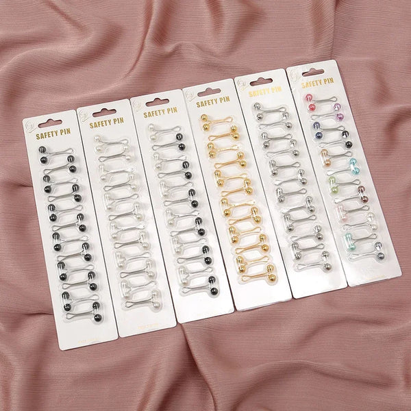 A set of safety pins in various colors and finishes packaged in individual plastic sleeves.
