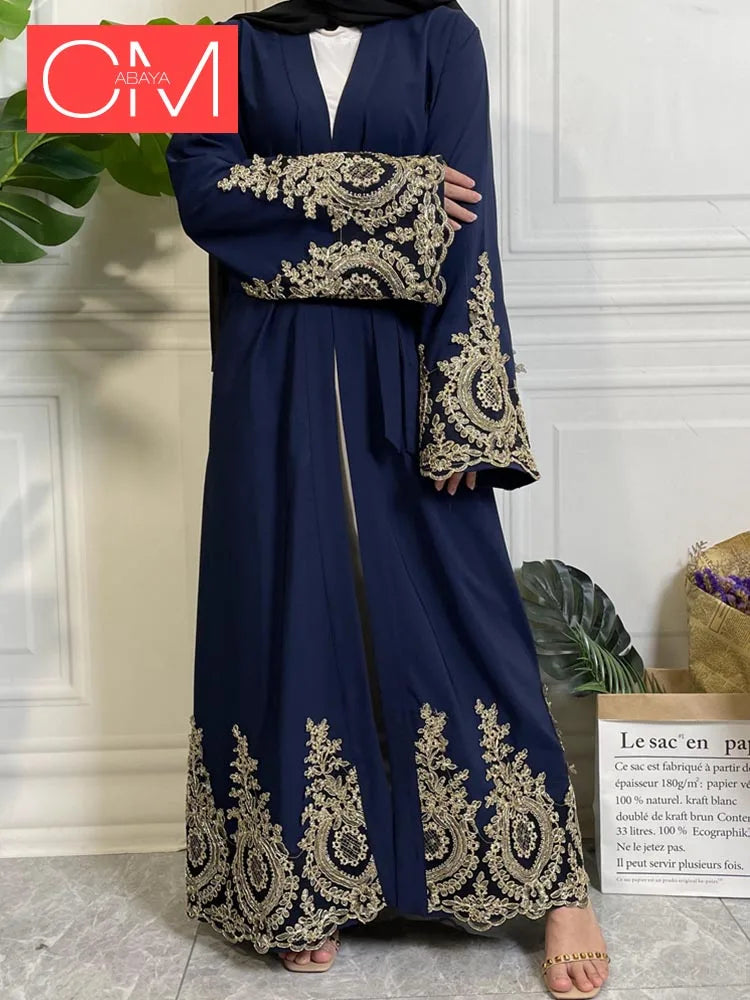 Una lujosa caftán abaya azul oscuro para mujeres con bordados dorados en las mangas y el dobladillo.