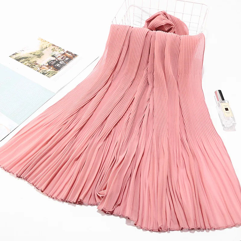 Pinkes Crinkle-Chiffon-Hijab-Tuch drapiert auf weißem Hintergrund.