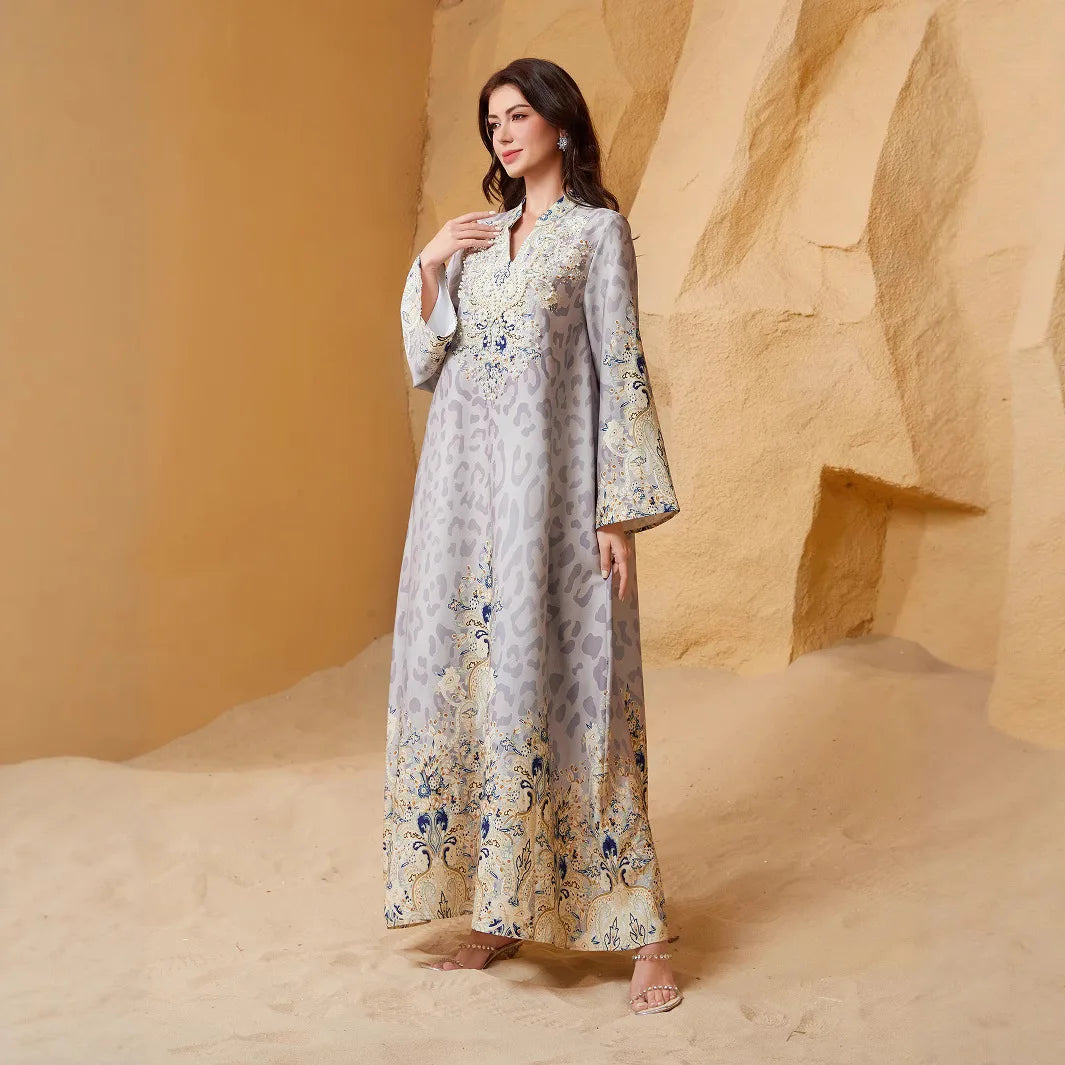 Una mujer vistiendo una abaya larga azul claro y beige con estampado de leopardo y adornos de diamantes, de pie en un entorno