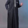 A man wearing a black Moroccan ethnic thobe with a stand collar and embroidery.
